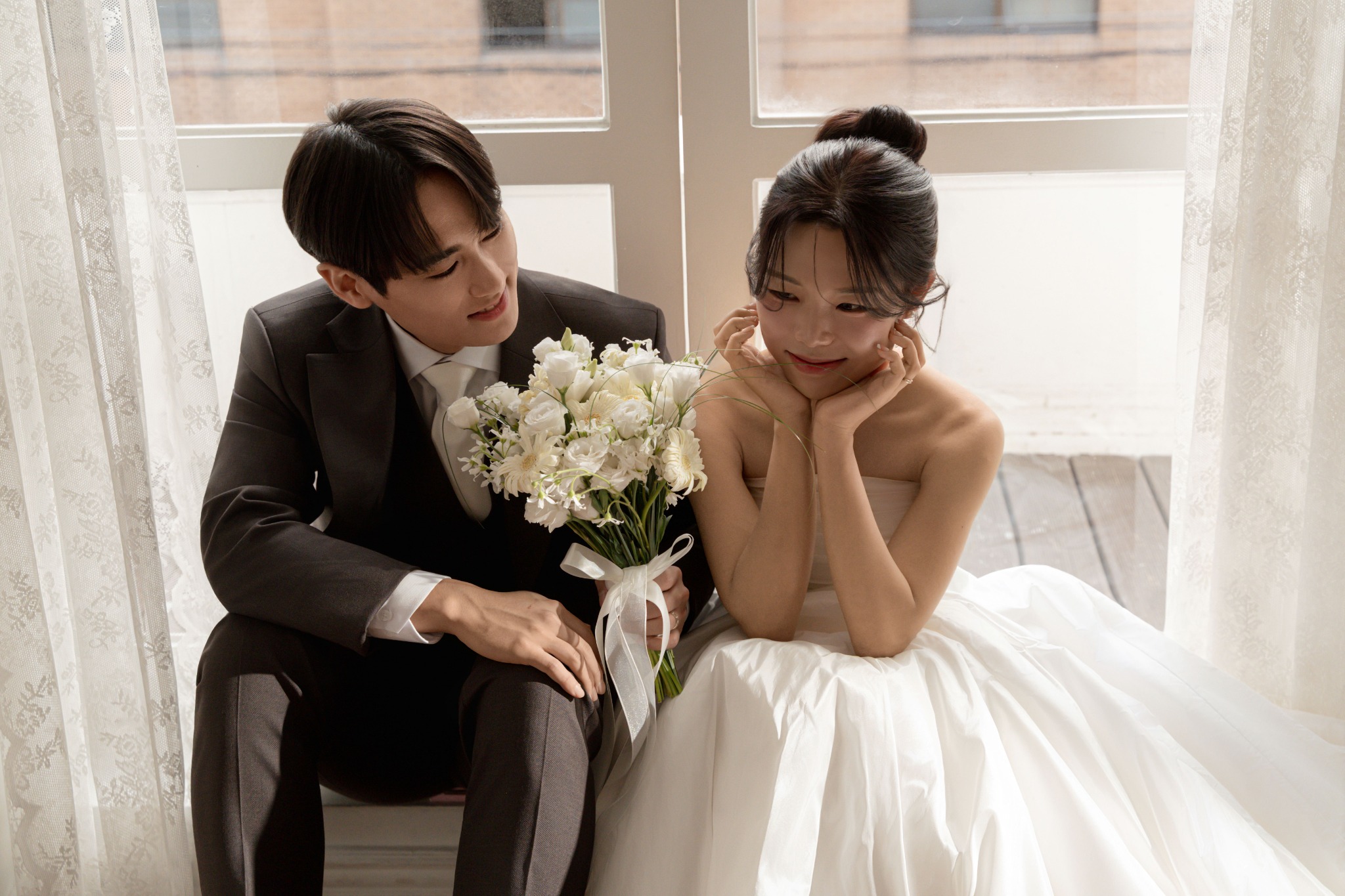 창가에서 꽃다발을 들고 함께 앉아 있는 태환과 소현